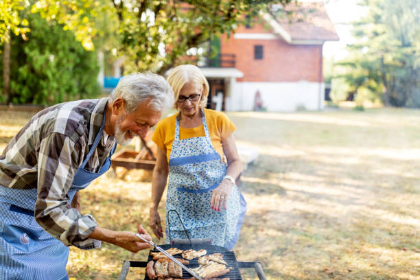 istock Cheerful senior making barbecue in back yard on a sunny day 1239993765