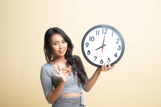 istock Young Asian woman show OK with a clock. 1240004041