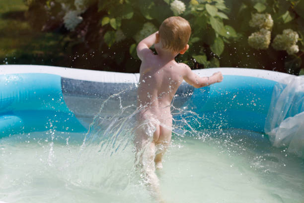 istock Cute little boy jumping in swimming pool. Backyard water fun 1240005155