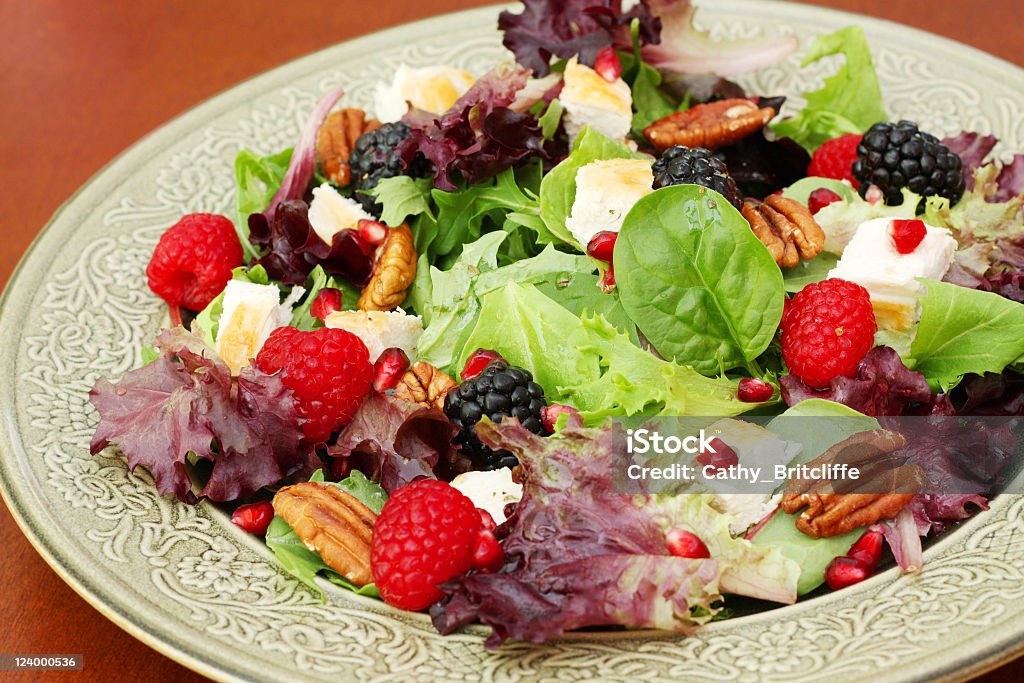 Chicken Salad A photograph of a plate of healthy chicken salad made with grilled chicken, baby greens, raspberries, blackberries, pomegranate and toasted pecans. Berry Fruit Stock Photo