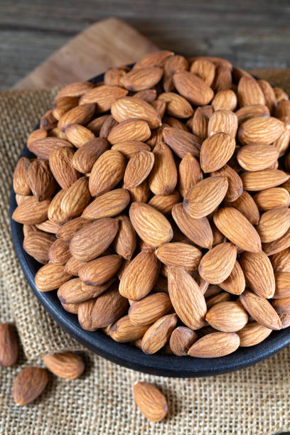 istock Almonds in round bowl on rustic wooden background 1240015575