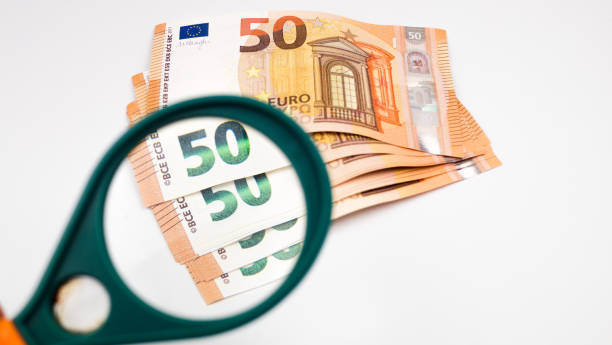 istock 50 euro banknotes under a magnifying glass on a white table 1240029993