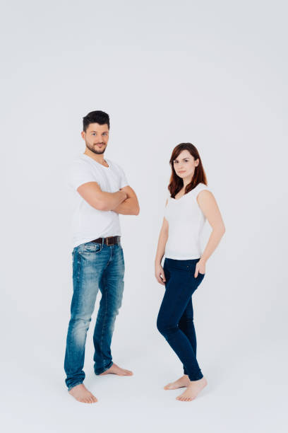 istock Attractive serious barefoot couple in jeans 1240031104