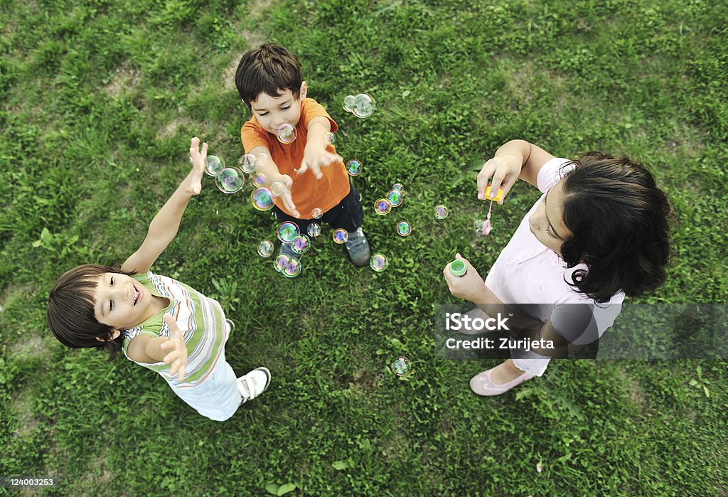 Kleine Gruppe von glückliche Kinder spielen zusammen und machen Blasen - Lizenzfrei Seifenblasenring Stock-Foto