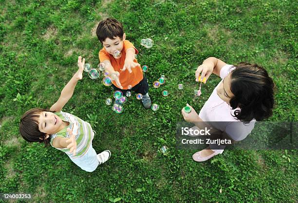 Piccolo Gruppo Di Bambini Felici Che Giocano Insieme E Bolle - Fotografie stock e altre immagini di Bolle di sapone