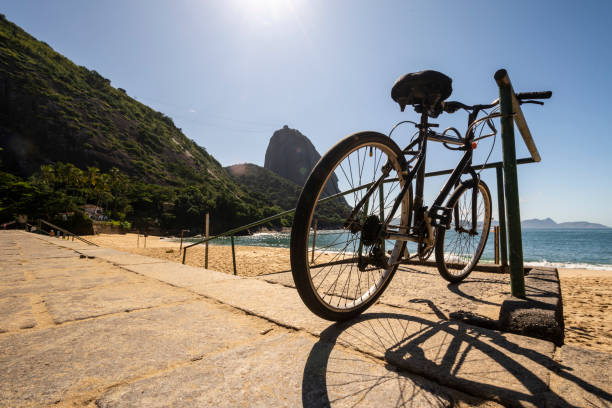 splendida vista sulla montagna di pan di zucchero da una spiaggia vuota - brazil bicycle rio de janeiro outdoors foto e immagini stock