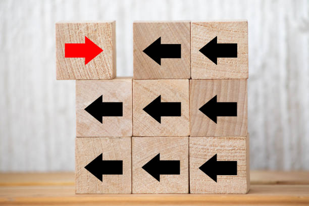 istock Wood cube presents red arrow facing opposite direction, Concept of think different, leadership mindset, people management and standing out from the crowd 1240070294