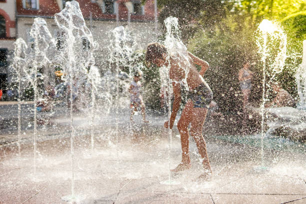 istock Child playing with water in park fountain 1240097292