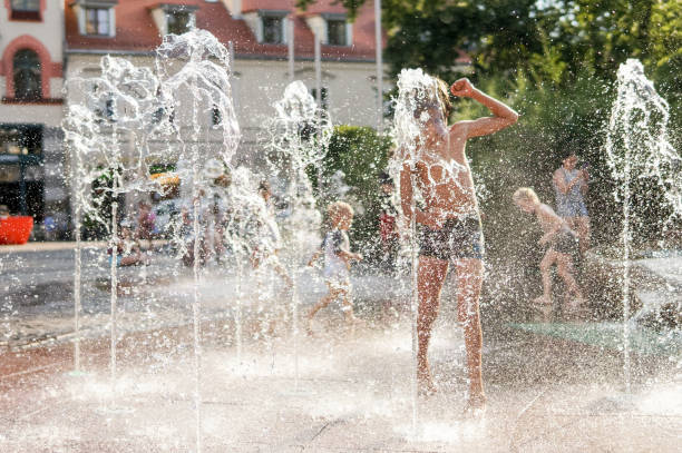 istock Child playing with water in park fountain 1240097302