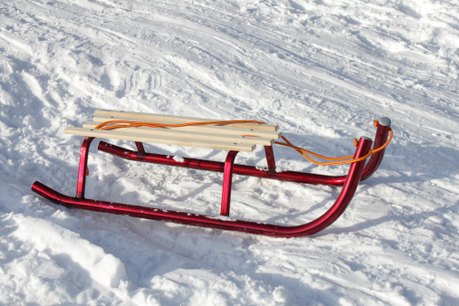view of wooden sled in front against snow mountain background