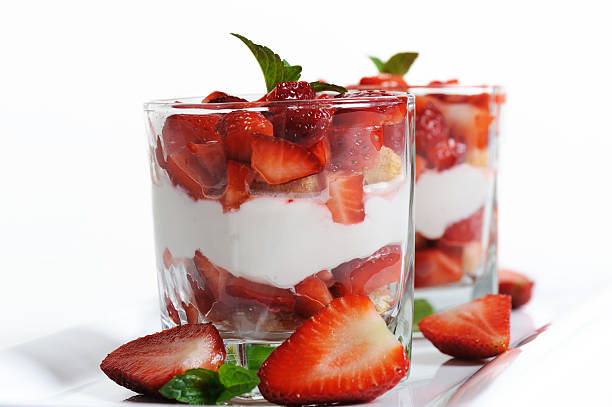 Dessert with strawberries on a bright yellow background in a glass bowl, macro