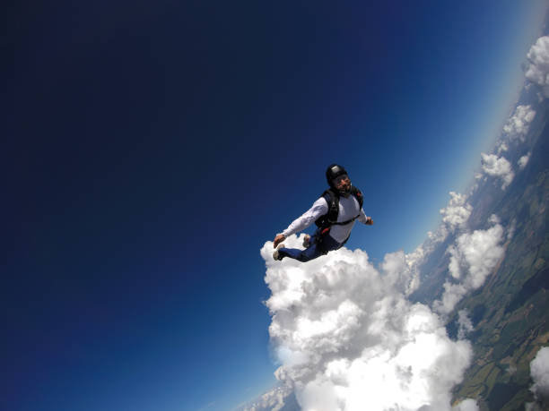 paraquedista pulando livre com as nuvens. - mergulho autónomo - fotografias e filmes do acervo