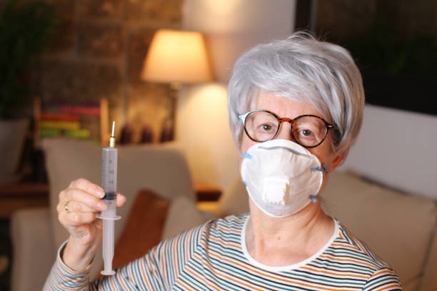 istock Senior woman holding the coronavirus cure 1240123706