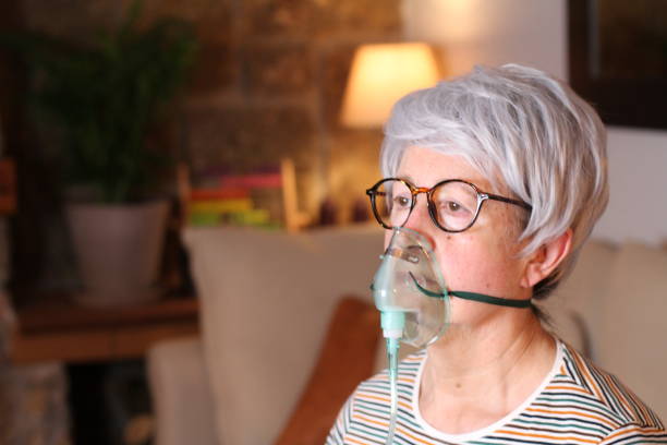 Senior woman receiving oxygen therapy Senior woman receiving oxygen therapy. oxygen cylinder stock pictures, royalty-free photos & images