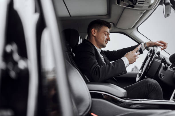 istock Happy businessman looking at phone screen in car 1240129414