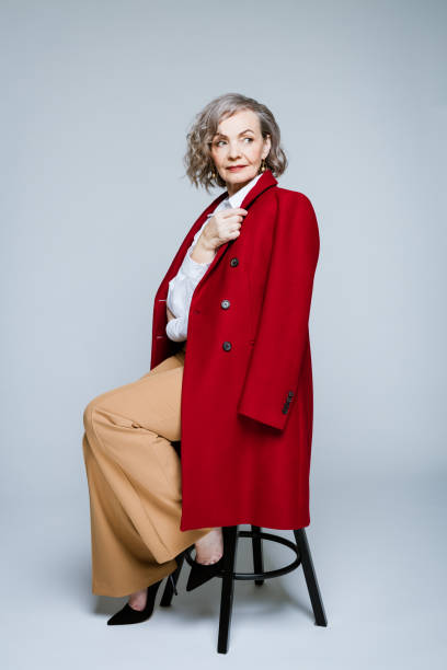 verticale de mode de femme aînée élégante utilisant le manteau rouge - model70 photos et images de collection