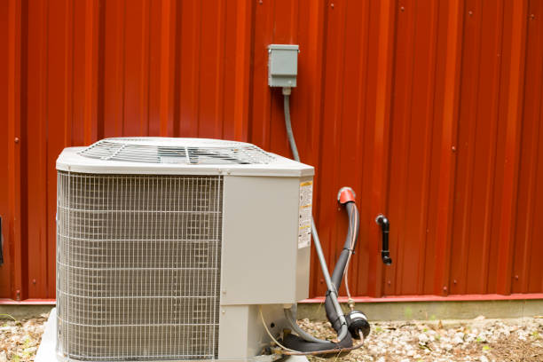 istock Outside Air conditioner unit beside red metal building. 1240133630