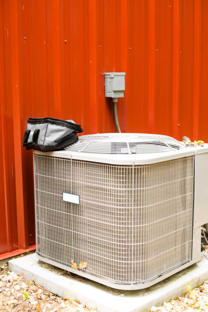 istock Outside Air conditioner unit beside red metal building. 1240136312