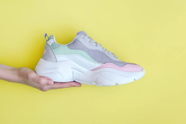 istock Human hand with a new sport sneaker. 1240137982