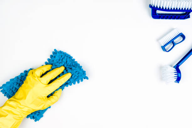 istock Tools for perfect cleaning. Floor cleaning brushes and a yellow-gloved hand with a floor rag. 1240139568
