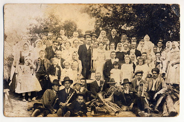 Old wedding photograph Group photoghaph taken at wedding in the Slovak village (Central Europe). In the foreground is a brass band. Date: 1920. Without image restoration. newlywed photos stock pictures, royalty-free photos & images