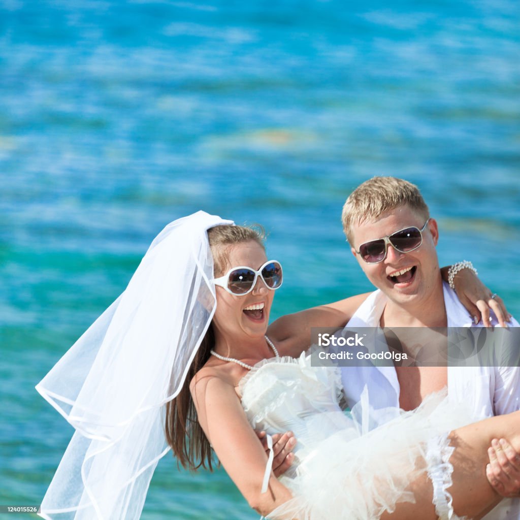 Tropical wedding Groom holding up a bride on the tropical beach Activity Stock Photo