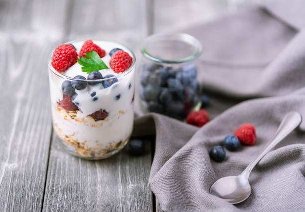istock White yogurt in glass jar with blueberries on grey background. 1240159870