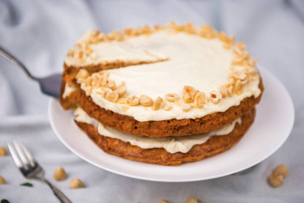 istock Carrot cake and hazel nuts on the white tablecloth, pie cooked with carrot biscuit and sour cream 1240170493
