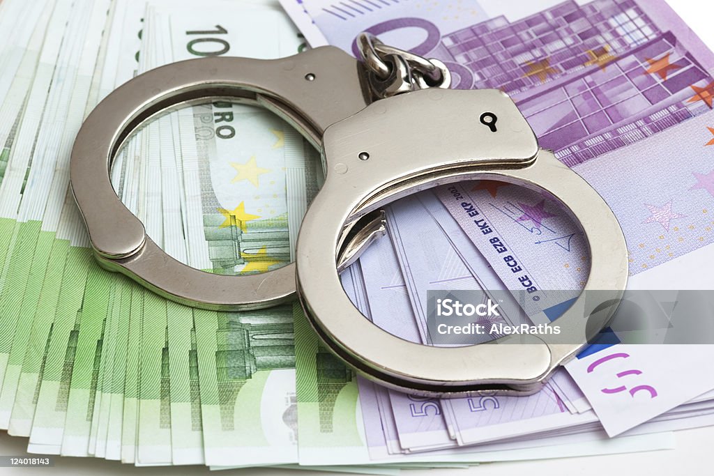 handcuffs Euro notes and handcuffs over white background Bankruptcy Stock Photo