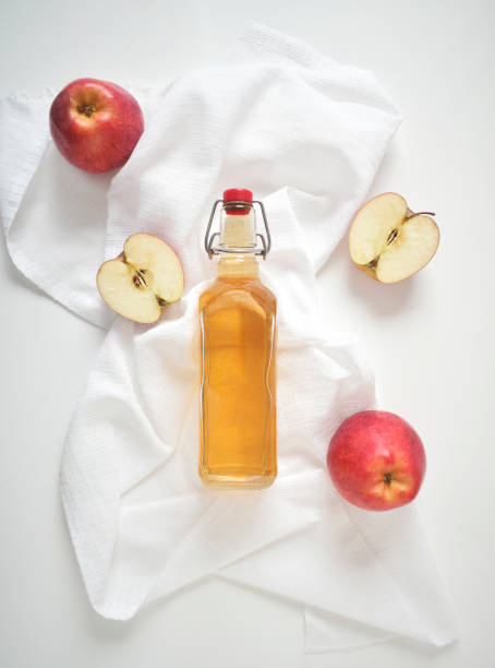 アップルサイダー酢または発酵フルーツドリンクと有機リンゴを白い、上の景色、コピースペースに。健康的な食事とライフスタイルの概念 - vinegar bottle herb white ストックフォトと画像