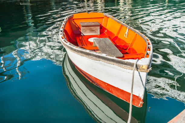 bote de madera pintado de color naranja brillante y blanco atado al muelle en boothbay - pemaquid maine fotografías e imágenes de stock
