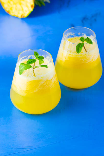 istock Pineapple cocktail on a blue background. Cold pineapple cocktail with mint. Summer tropical cocktail. Healthy drink. Copy space 1240204912