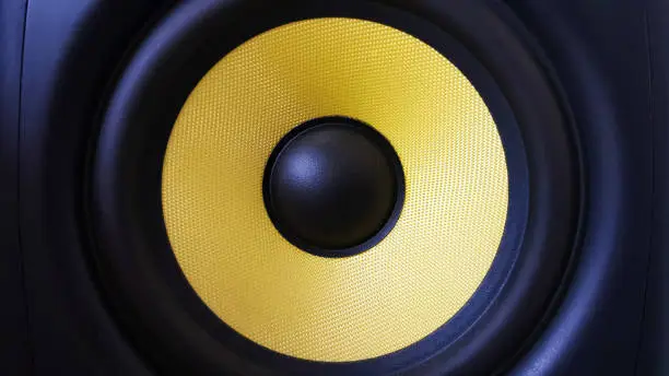 Speaker background. Woofer, yellow subwoofer close-up. Professional studio equipment. Vocal monitor for mixing and recording music. High quality desk monitors