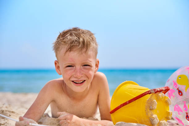 istock LITTLE BOY LIES ON A SEA SANDY BEACH. 1240214253