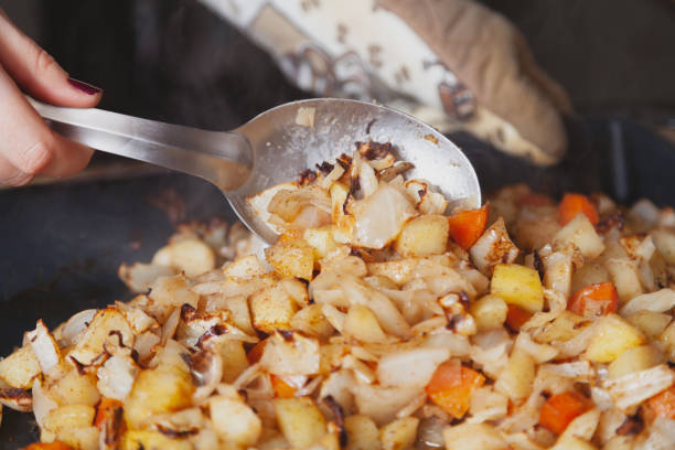 istock Large spoon stirs stewed vegetables on baking sheet 1240217999