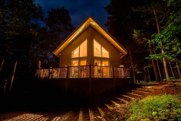 vacation home in woods at night - cabin imagens e fotografias de stock