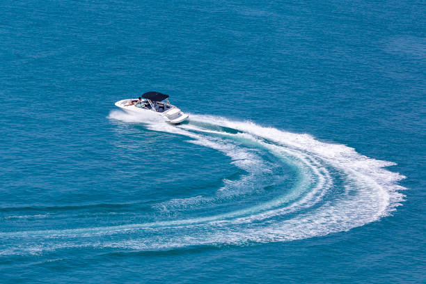 il motoscafo ricreativo ad alta velocità fa una svolta improvvisa in mare - recreational boat motorboat speedboat aerial view foto e immagini stock