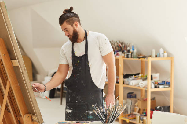 istock Bearded Artist Painting on Easel in Workshop 1240227660