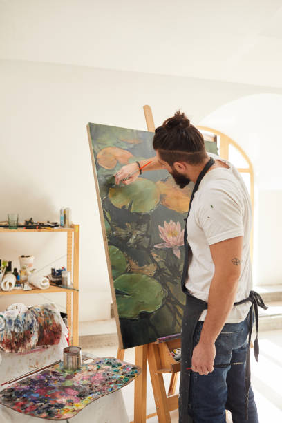 istock Modern Bearded Man Painting on Easel in Studio 1240227667