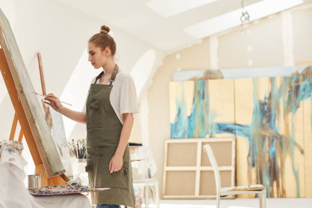 istock Female Artist Painting on Easel 1240227677