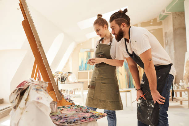 istock Cheerful Creative Couple Painting Picture on Easel 1240227694