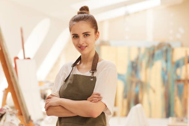 istock Smiling Female Artist Posing in Art Studio 1240227719