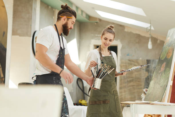 istock Modern Creative Couple Painting Together in art Studio 1240227731