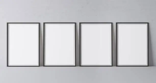 Four black vertical frames mock up. Frame poster size A4, A3 standing on gray floor. Stock photo
