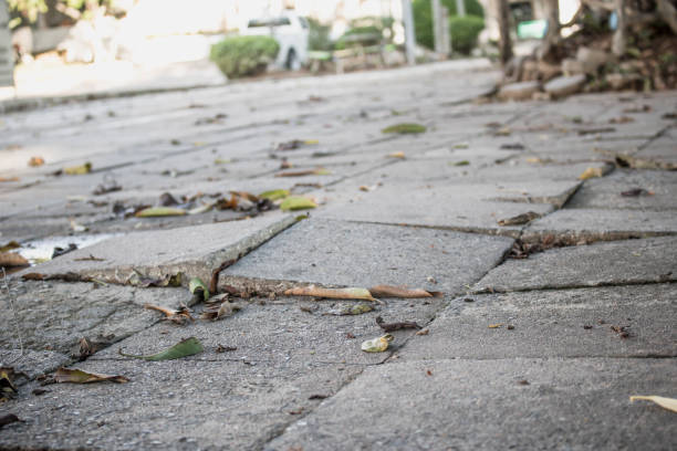 istock Broken concrete pathway brick surface background, close up abstract cracked cement block texture. Gray floor. 1240242715