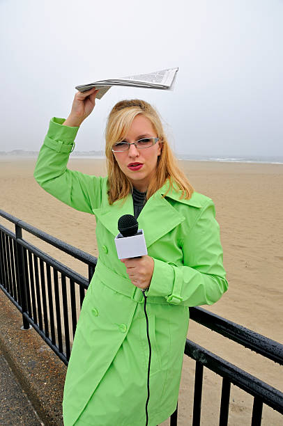 Female Newscaster Reports from Beach stock photo
