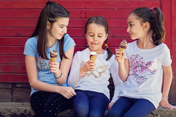 Girlfriends are eating ice cream and making fun together Girlfriends are eating ice cream and making fun together stealing ice cream stock pictures, royalty-free photos & images