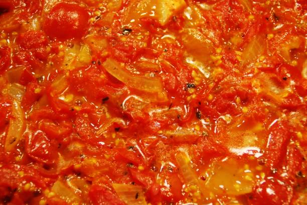 Cooking vegetable stew, tomatoes sprinkled with dried herbs.