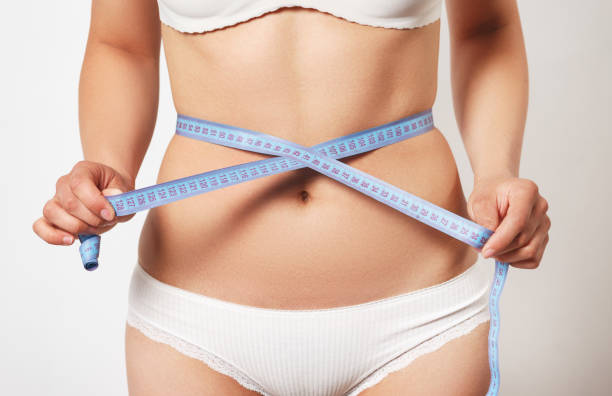 istock Woman measuring her slim body on white background 1240261755