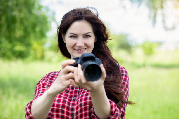 istock Woman smiles with a camera in her hands . 1240275657